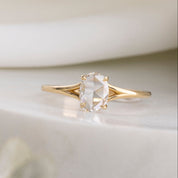 Gold ring with a clear gemstone on a light background