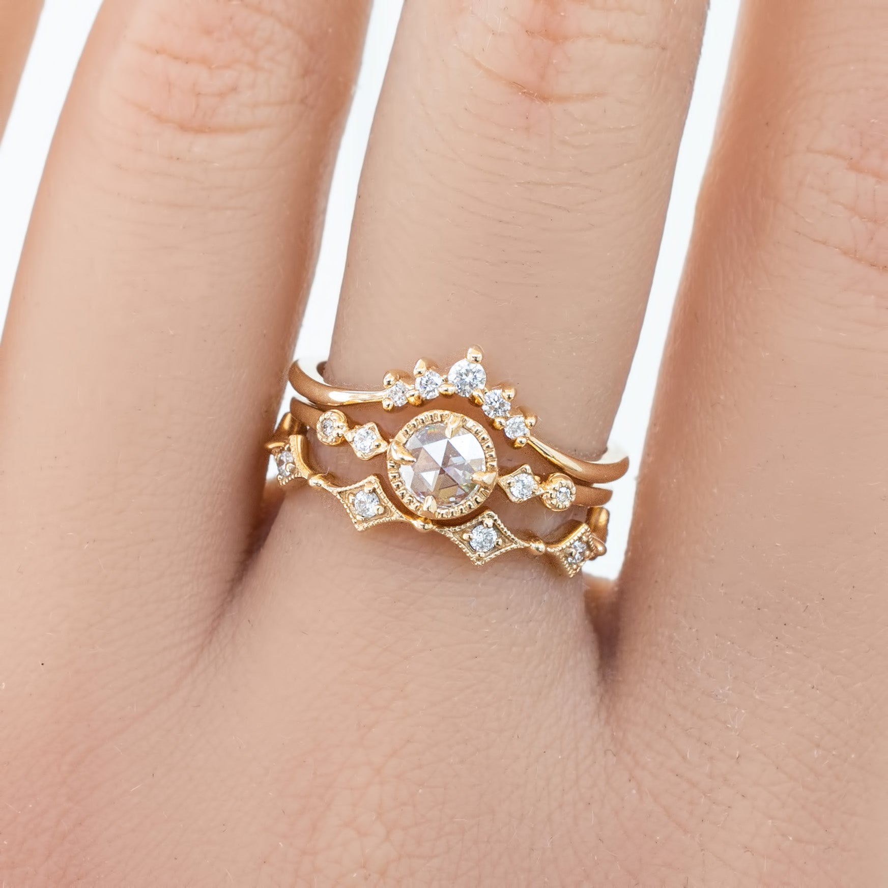 Close-up of a hand wearing a gold star diamond eternity ring with natural white diamonds in an intricate design