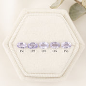 Five oval-shaped lavender gemstones labeled A to E on a textured beige surface.