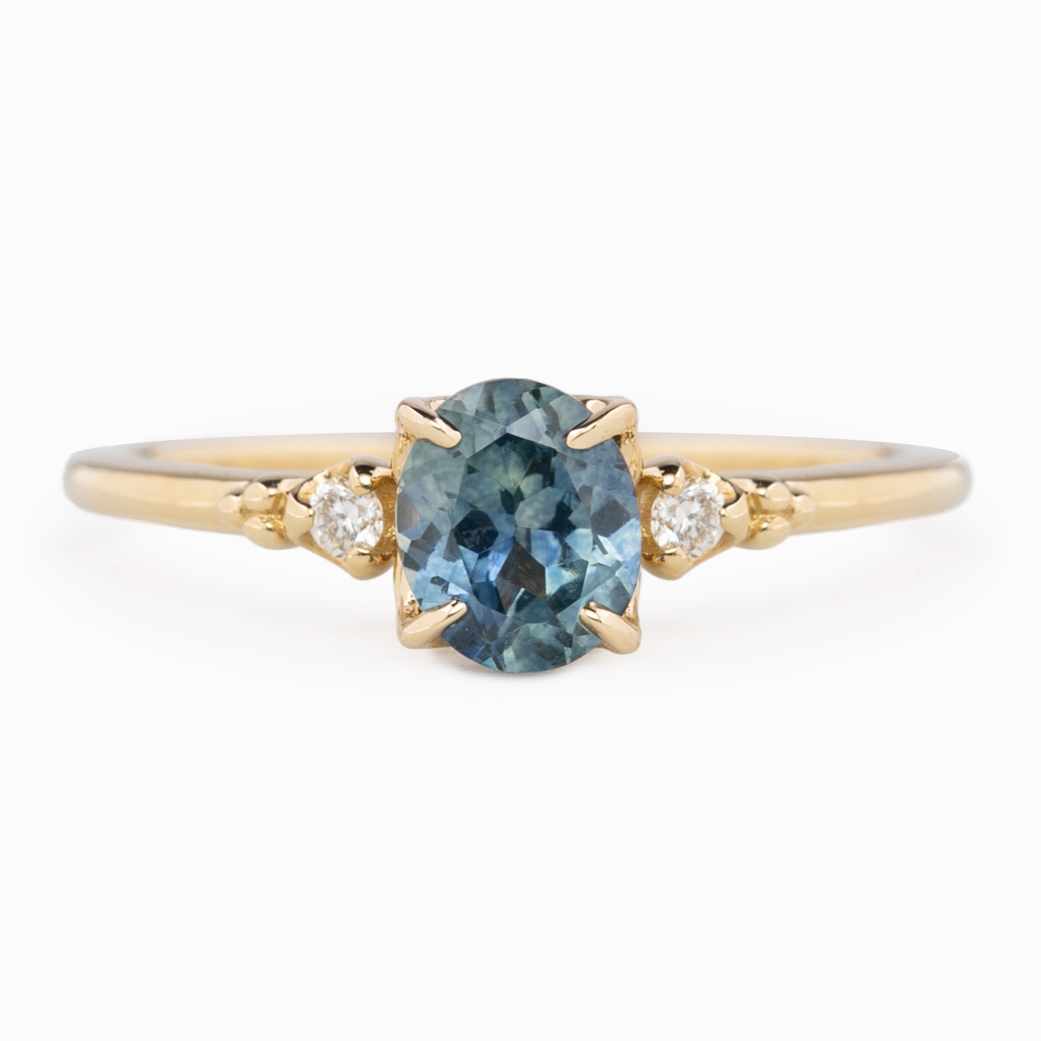 Estel Ring featuring an oval 0.85ct oval teal Montana sapphire with natural diamond accents in 14k yellow gold