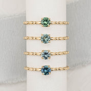 Four different Montana sapphire rings in different shades of blue green in 14k yellow gold solitaire ring setting