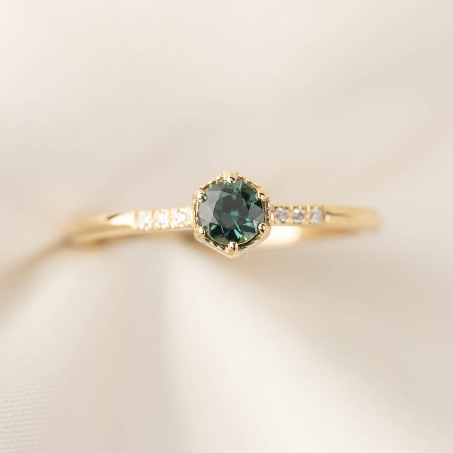 Hexagon ring with a teal blue sapphire and natural diamond accents in 14k yellow gold 