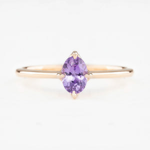 Ring with a purple gemstone on a white background