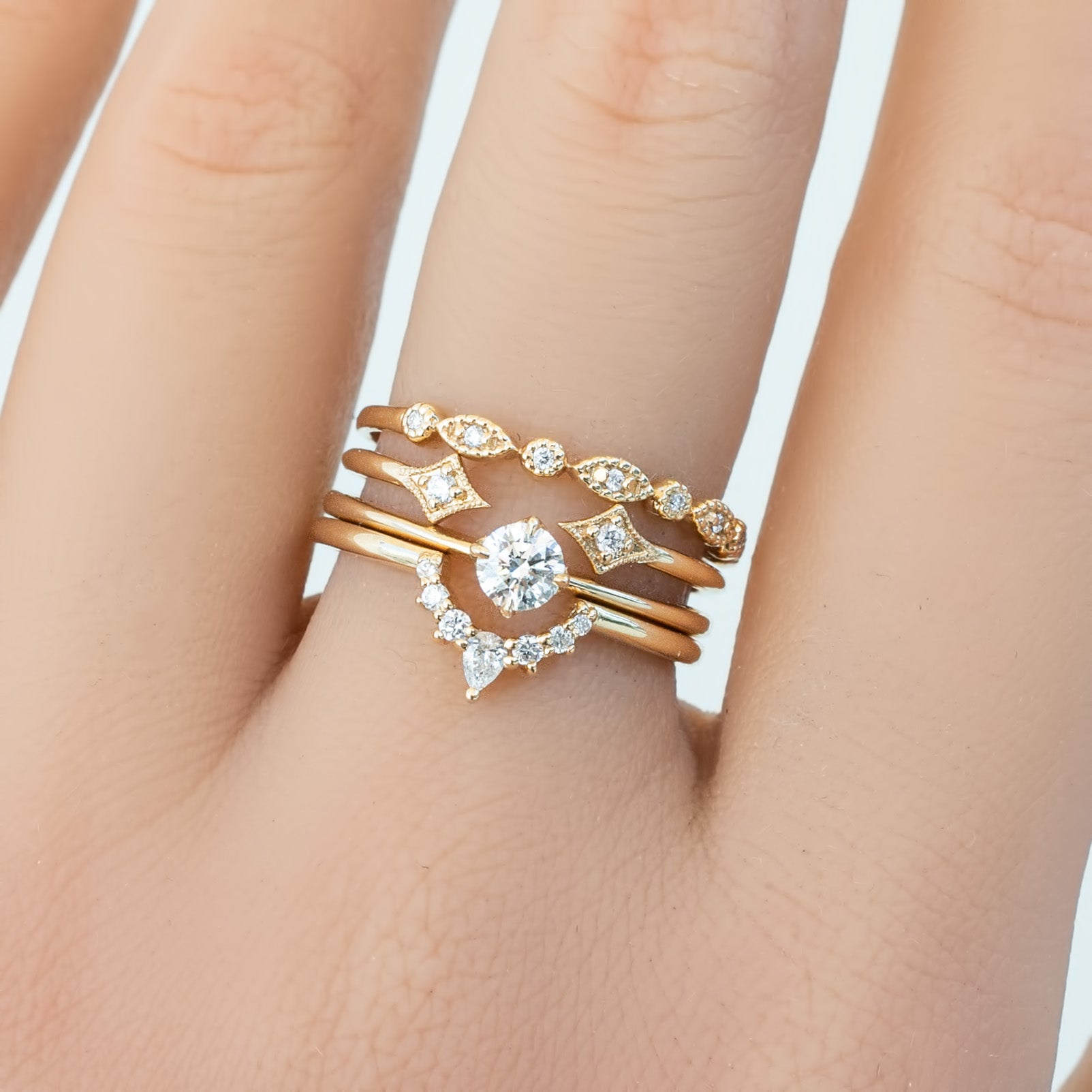 Close-up of hand wearing art-deco inspired Tia Petite Half & Full Eternity Ring with natural white diamonds on gold band