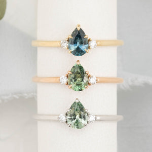 Three gold rings with pear-shaped sapphire in 14k yellow gold, rose gold and white gold
