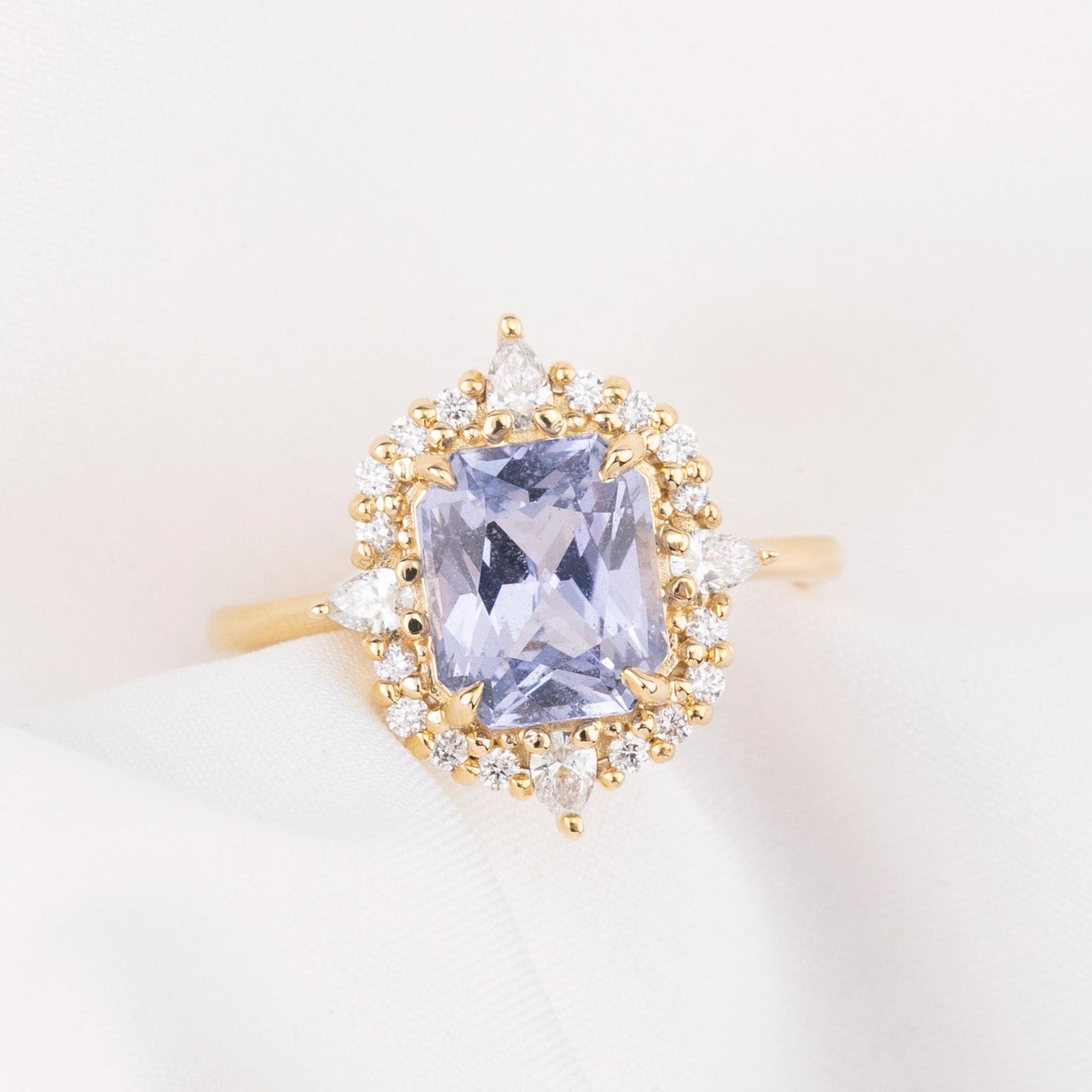 Gold ring with a purple blue sapphiree on a light background