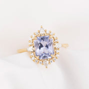 Gold ring with a purple blue sapphiree on a light background