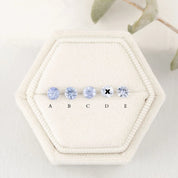 A series of round blue sapphires, set in a row, displayed in a hexagonal white box with each labeled A to E.