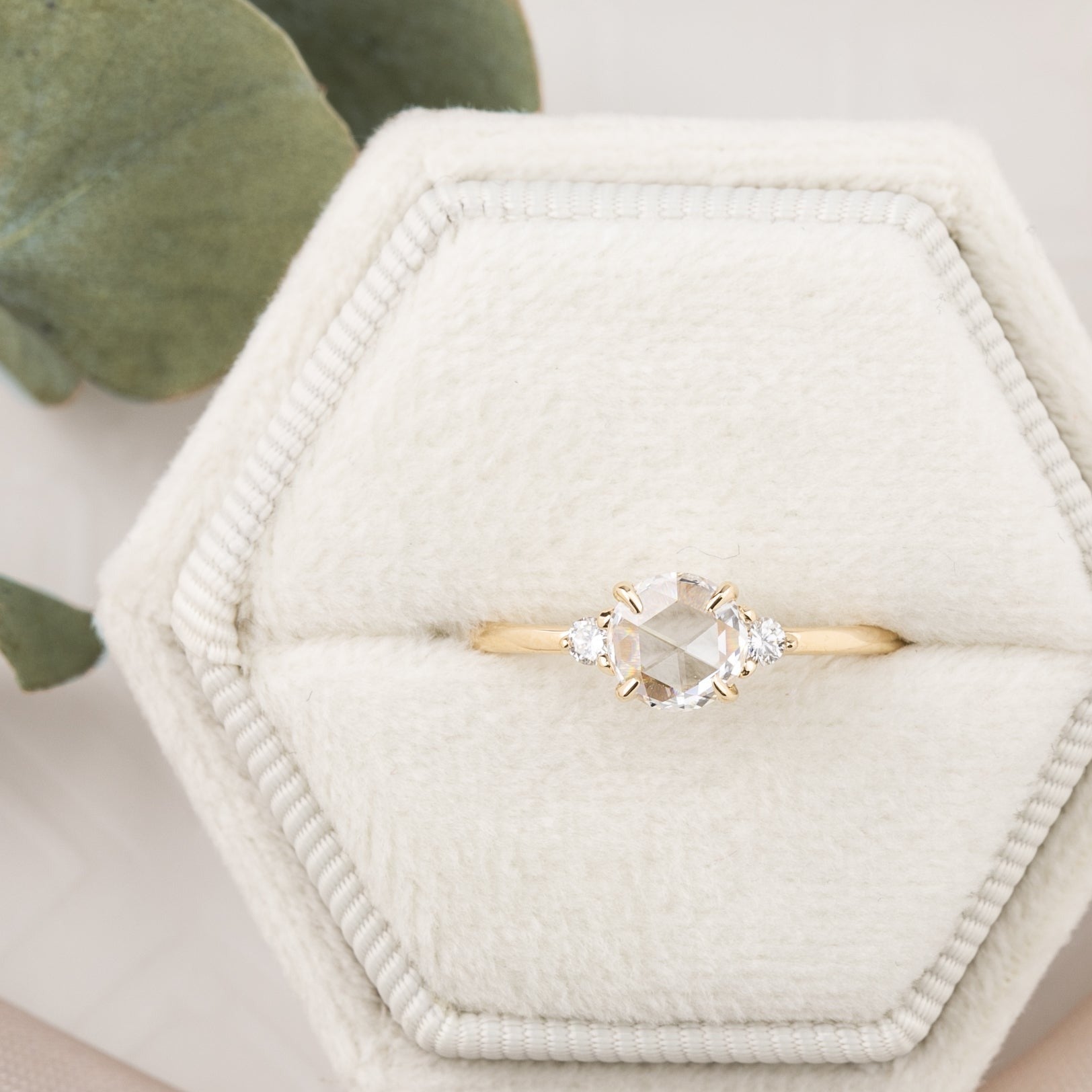 A 14k yellow gold ring with a 0.50ct round cut rose cut diamond center stone, displayed in a velvet ring box.