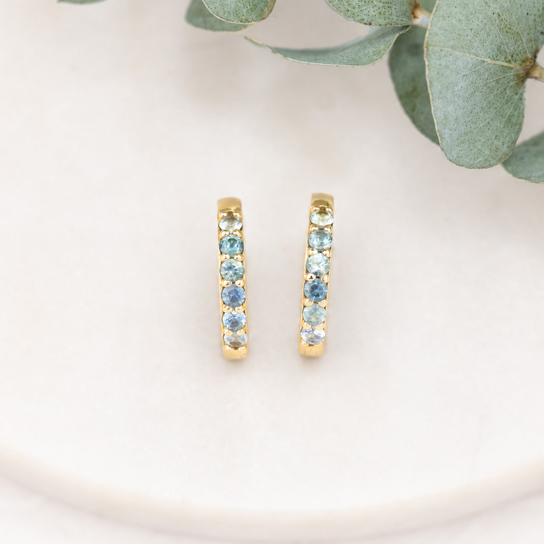 14K gold 15mm Montana sapphire huggie earrings with blue and green ombré sapphires