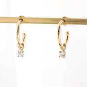 Gold hoop earring with measurements of appx 13.5mm diameter on a white background