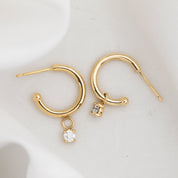 Gold hoop earring with measurements of appx 13.5mm diameter on a white background