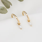 Gold hoop earring with measurements of appx 13.5mm diameter on a white background