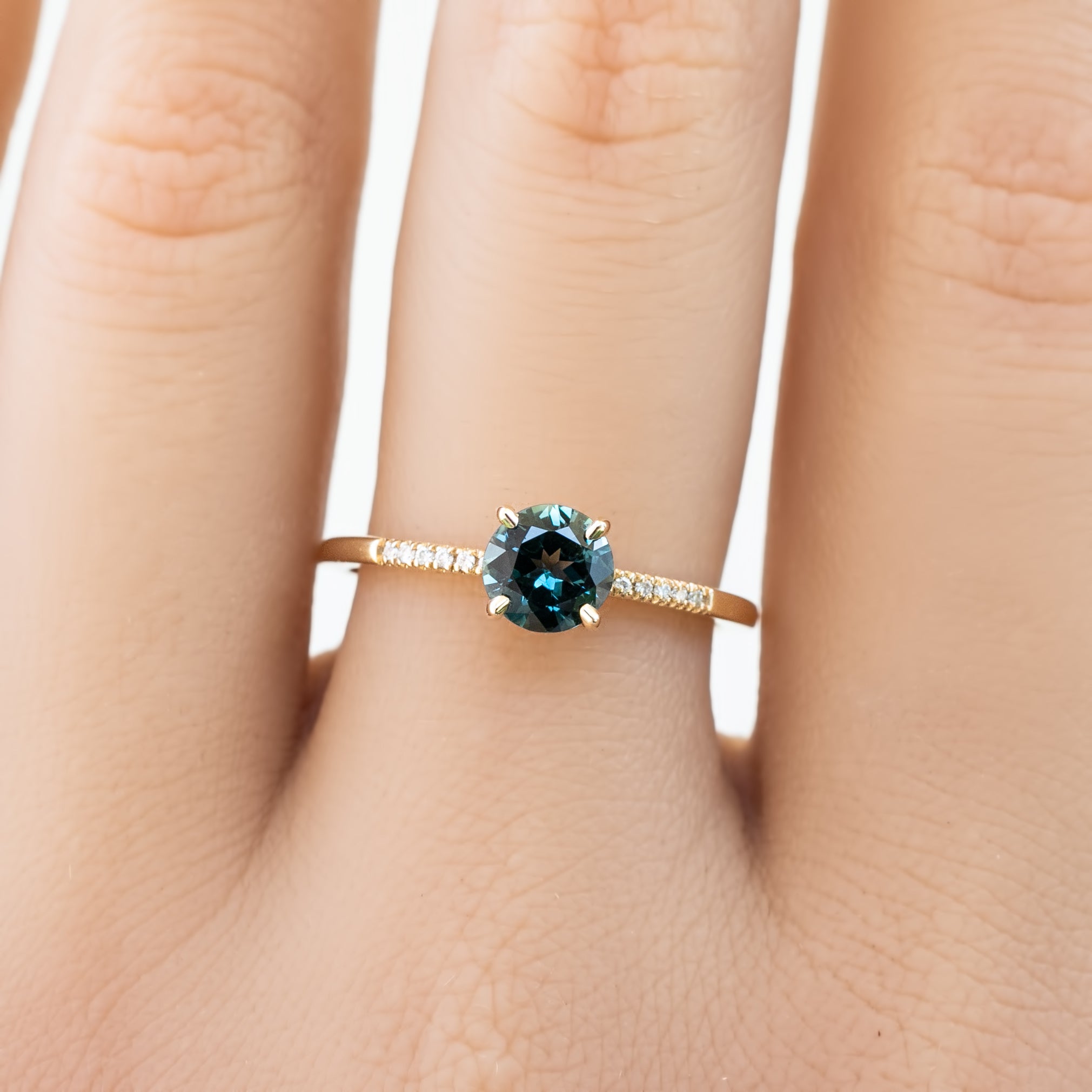 Audrey Ring, 0.73ct Queensland Sapphire with a green gemstone on a white background