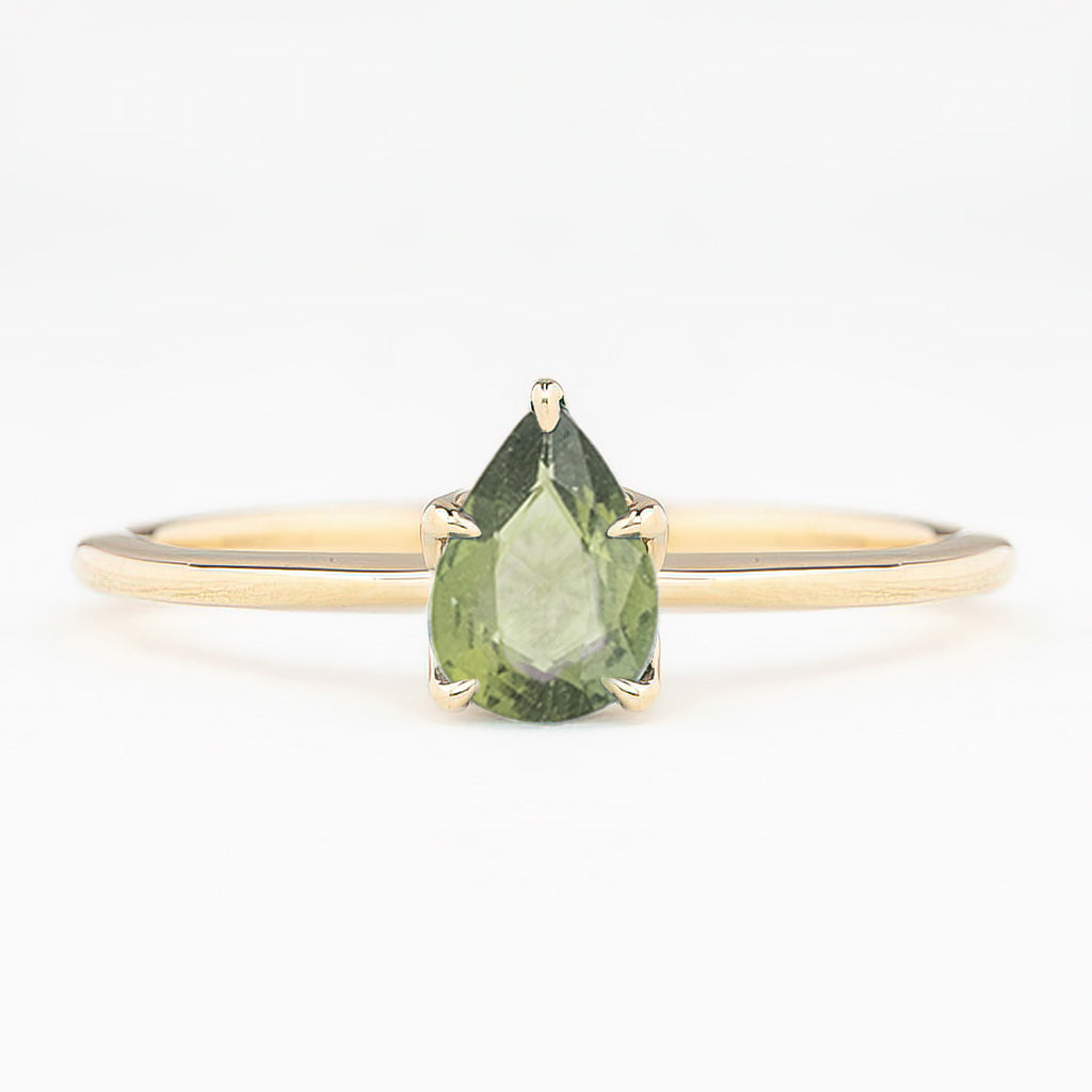 Gold ring with pear-shaped unheated green sapphire in a five-prong setting on a slim band