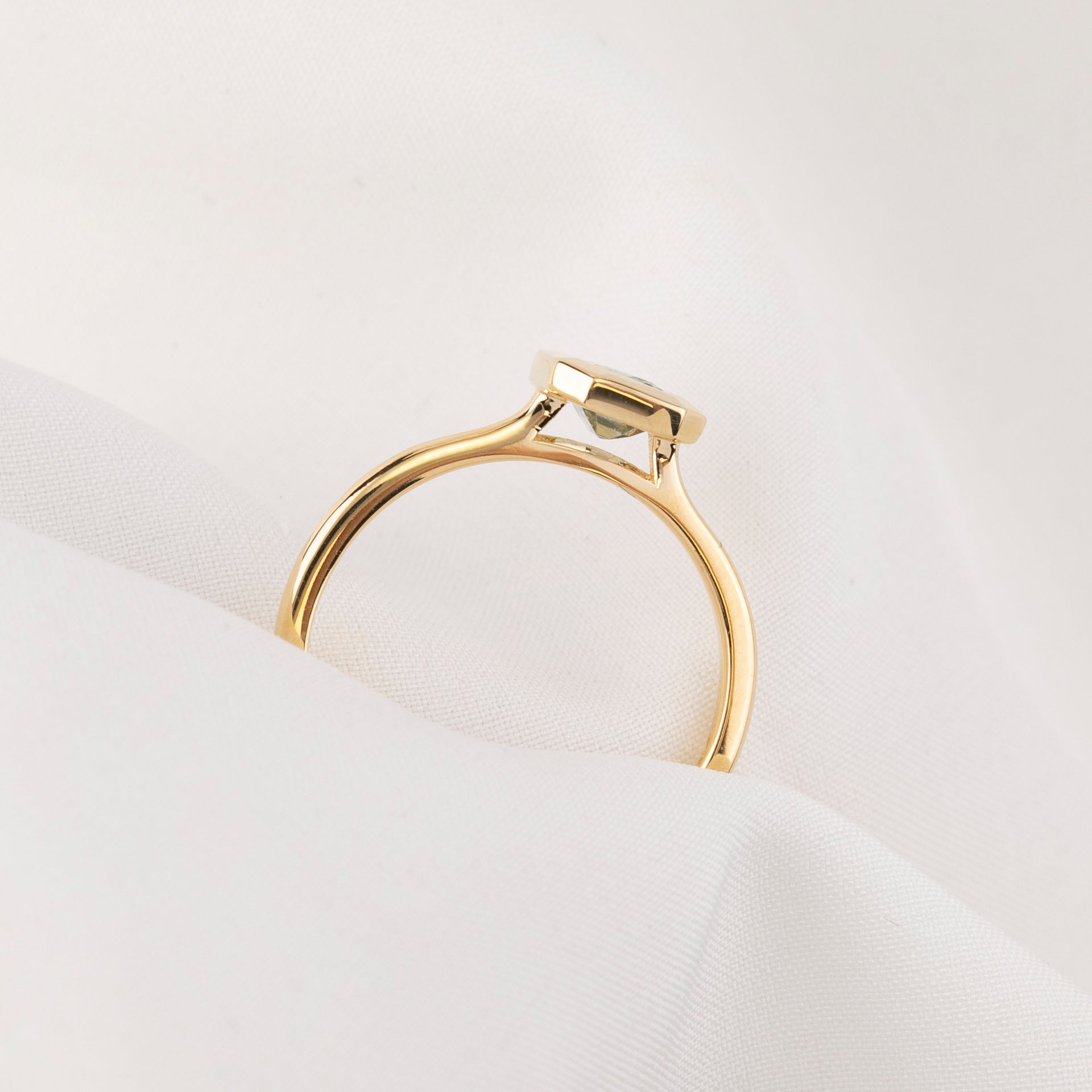 Gold ring with a diamond on a white background