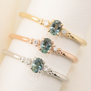 Three Estel Ring featuring a 0.20ct blue green unheated oval sapphire and 14k gold diamond accents