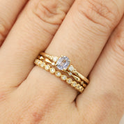 Estel Ring featuring a 0.40ct light blue unheated oval sapphire and 14k gold diamond accents stacked with 2 natural diamond yellow gold bands