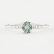 A 0.45ct unheated oval sapphire set in 14k gold with a sparkling diamond pave band.