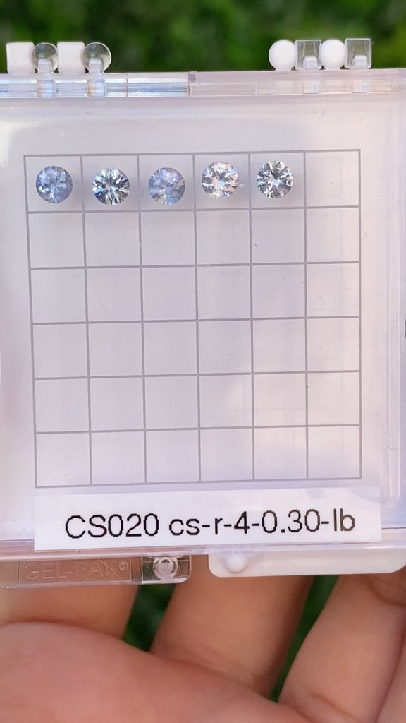 A series of round blue sapphires, set in a row, displayed in a hexagonal white box with each labeled A to E.