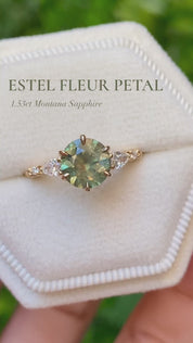 Video of Estel Fleur Petal Ring with a 1.53ct round green Montana sapphire and diamond accents in 14k yellow gold on a finger and stacking band.