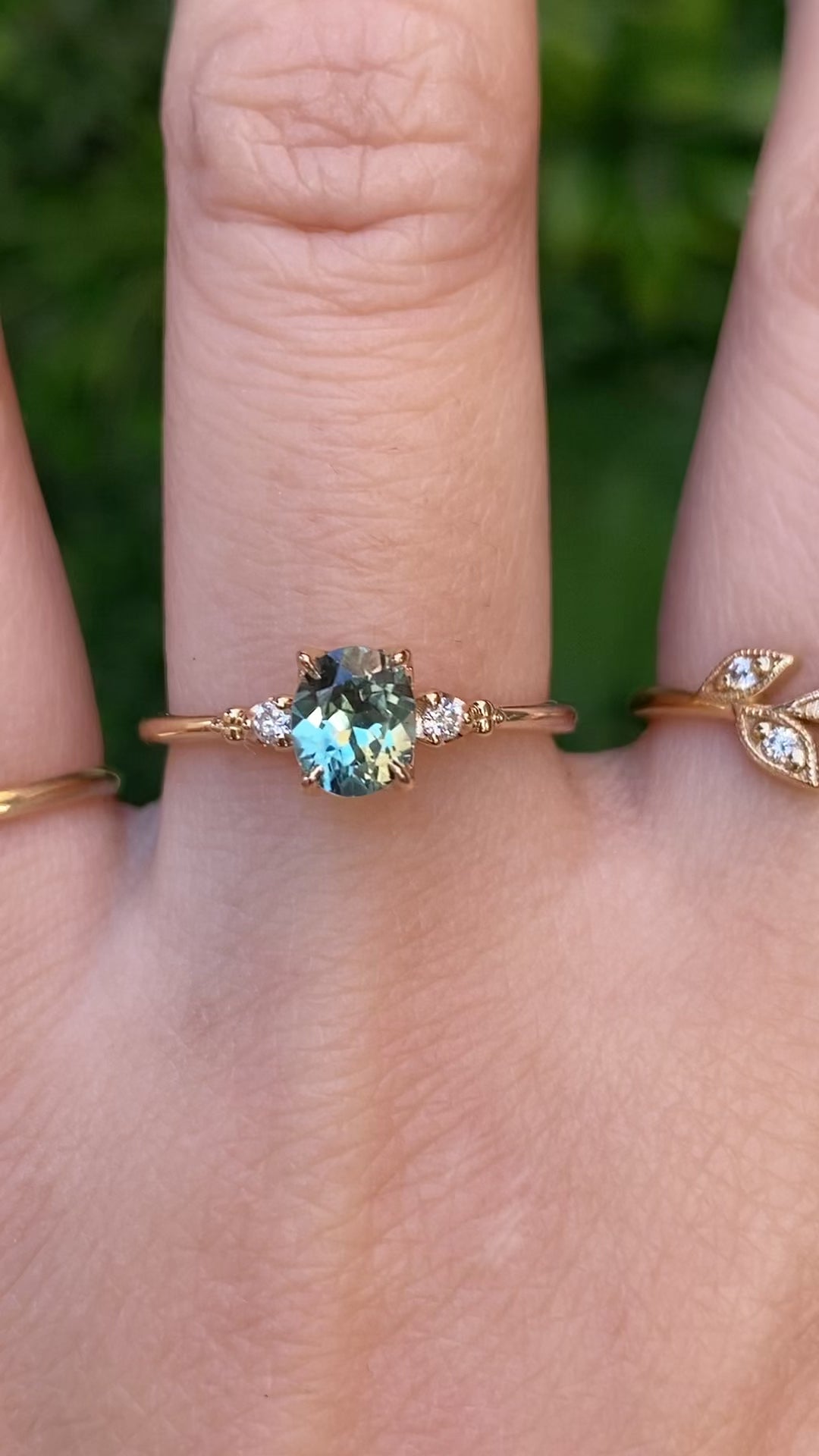 Estel Ring featuring an oval green Montana sapphire with natural diamond accents in 14k gold on finger