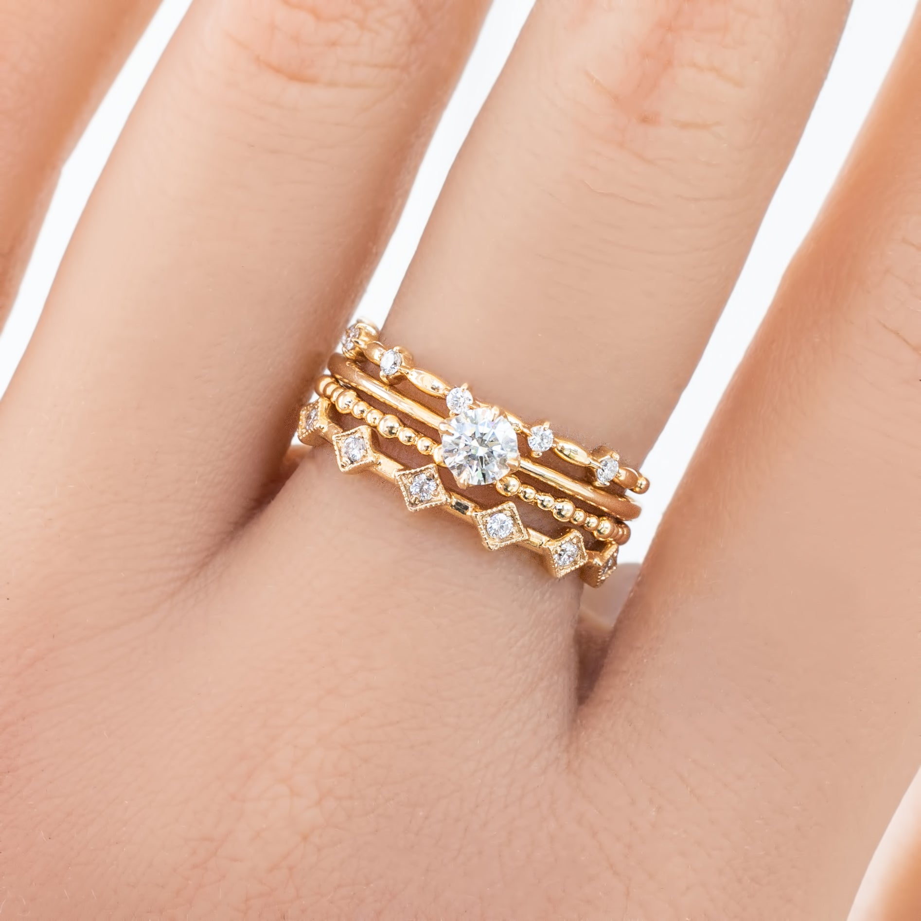 Distant Star Ring set with natural white diamonds in solid gold on a hand, displaying intricate band designs.