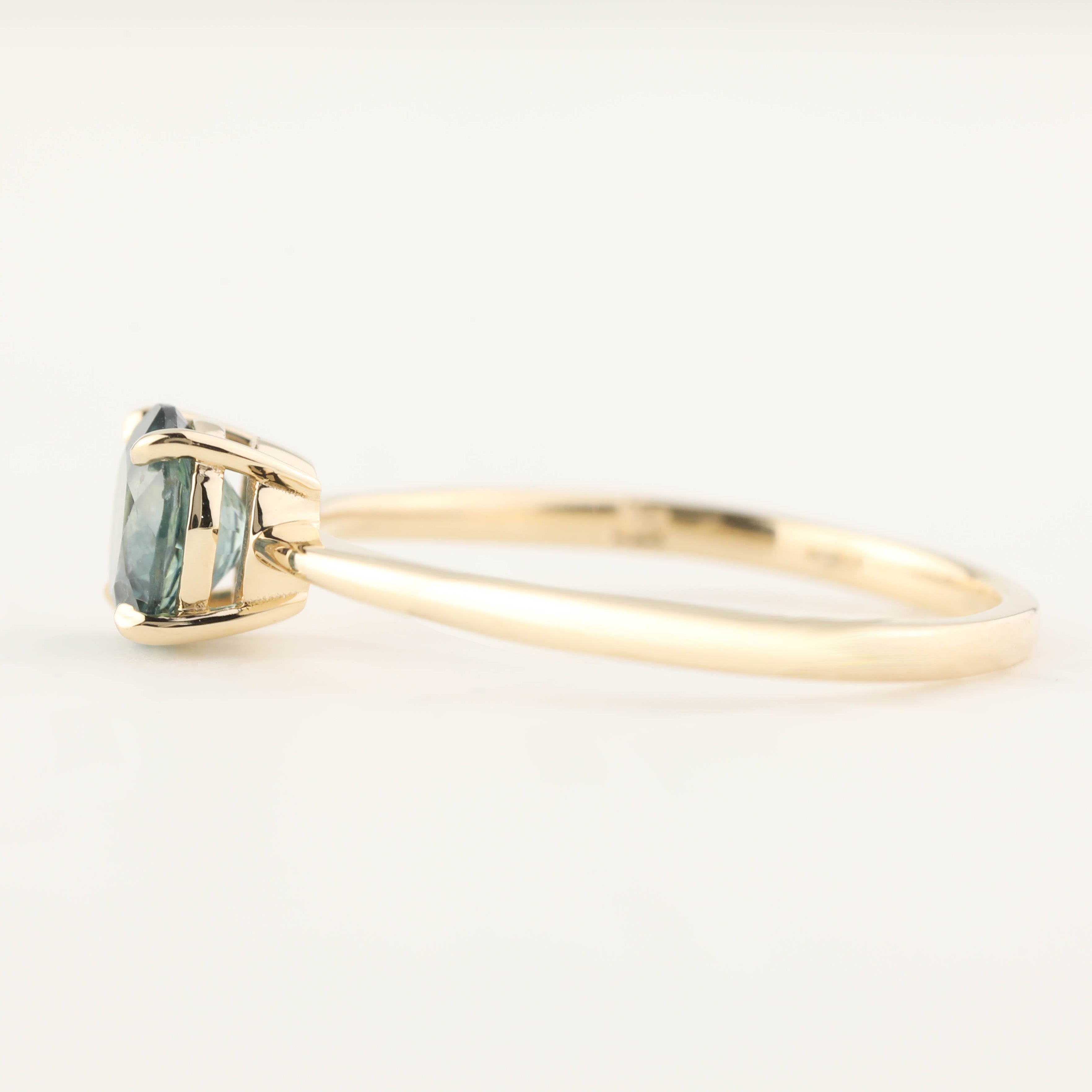 14k yellow gold Nina ring with 0.94ct teal blue Montana sapphire in classic low profile four-prong setting