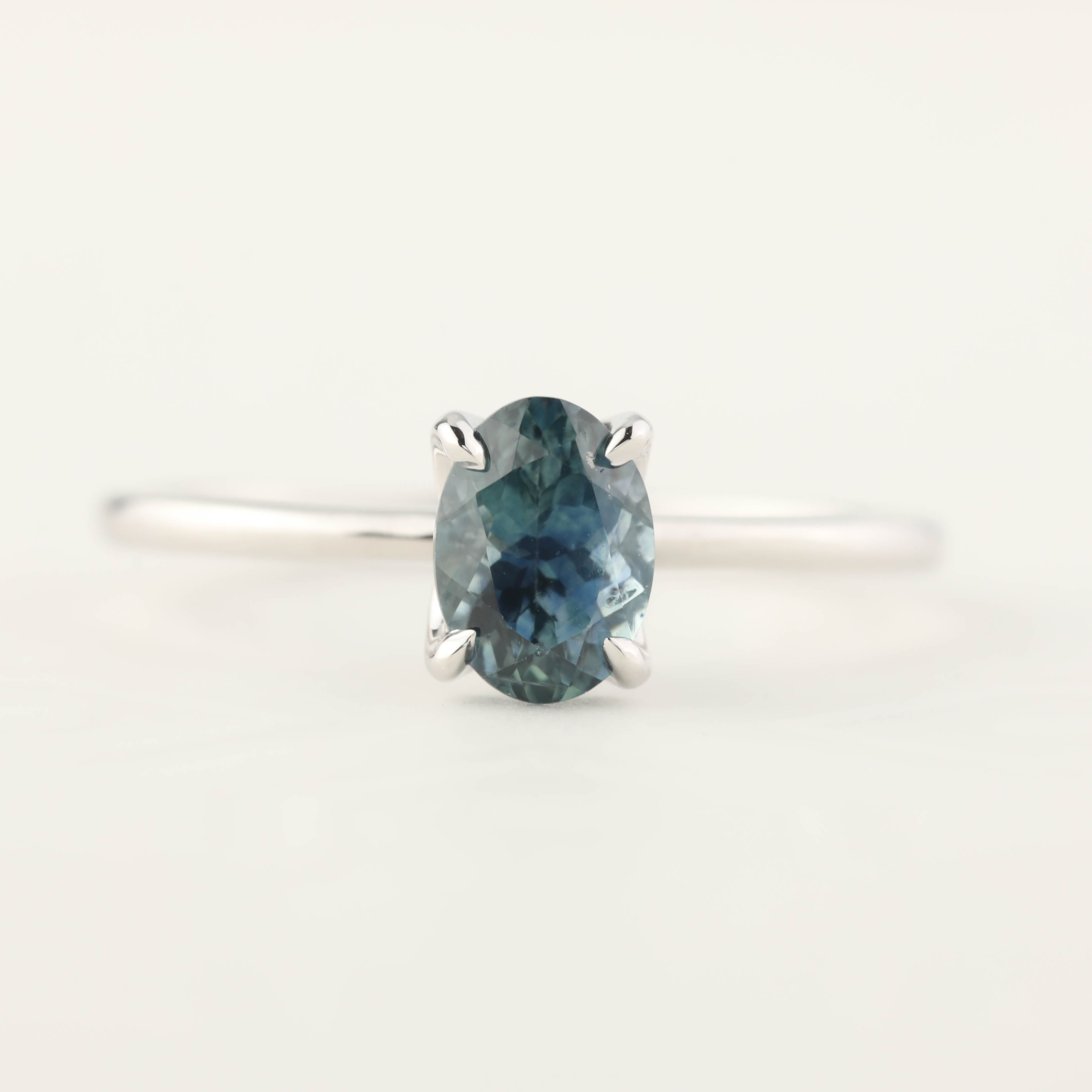 14k white gold ring with 1.00ct oval parti blue green Montana sapphire in a high profile flower setting