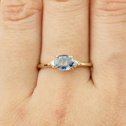 14k gold ring with 0.97ct oval blue sapphire and small white diamond accents on finger