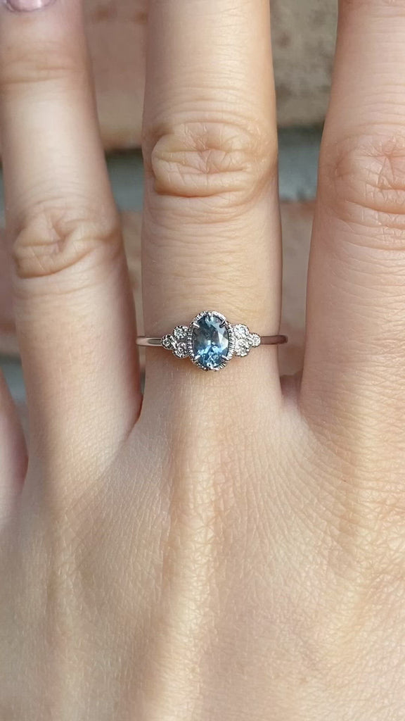 Celine Ring featuring a 0.60ct blue Montana sapphire in a 14k white gold with six natural diamond accents on a hand