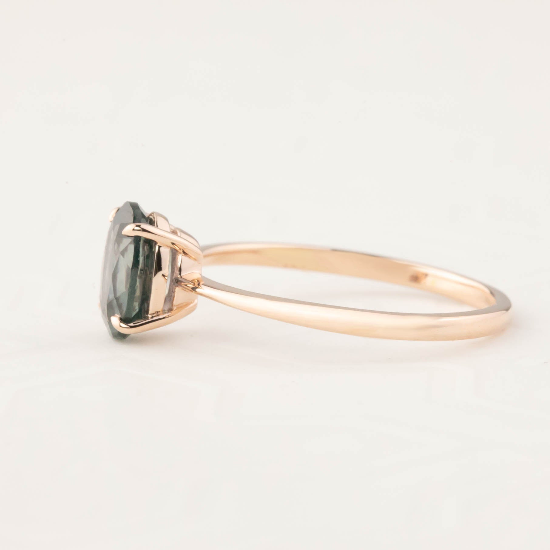 Side view of Nina Ring featuring 1.53ct peacock Montana sapphire set in 14k rose gold with a tapered band