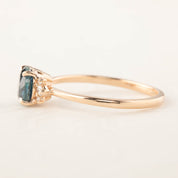 Side view of Lena ring with 1.15ct teal blue Montana sapphire and 14k rose gold band, classic low-profile setting.