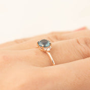 Lena Ring with 1.16ct Montana sapphire and white diamonds set in recycled 14k rose gold on a hand.