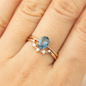 Rose gold ring featuring a 1.22ct teal blue Montana sapphire with small accent diamonds on finger size 7