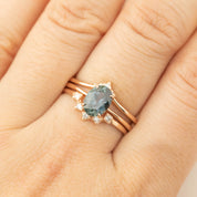 Close-up of a peacock Montana sapphire ring set in recycled 14k rose gold with diamond accents on a hand