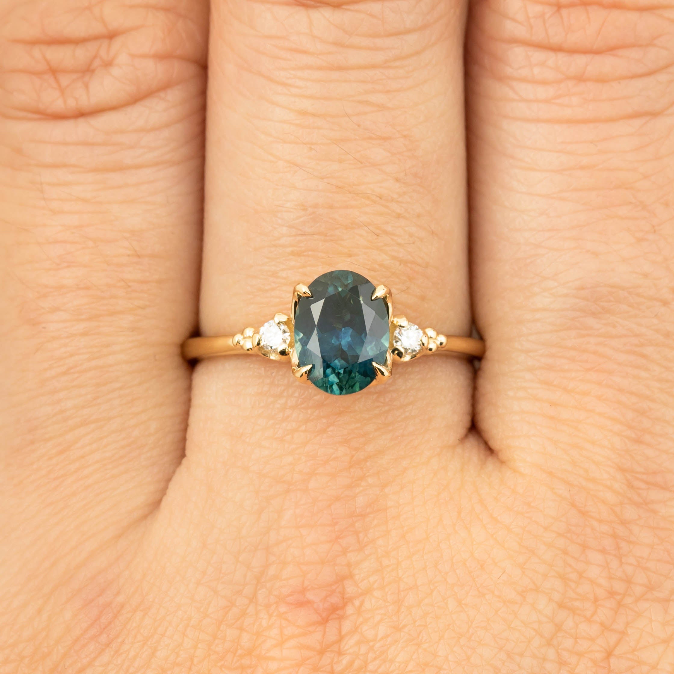 One of a kind 1.56ct teal blue Montana sapphire ring with white diamond accents in recycled 14k gold band