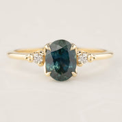 14k gold ring with 1.56ct teal blue Montana sapphire and two white accent diamonds in flower setting