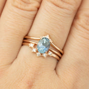 Close-up of a 1.4ct blue Montana sapphire ring set in recycled 14k rose gold with diamond accents on a hand.