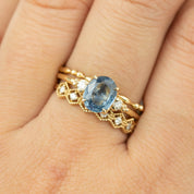 Close-up of hand wearing Estel Ring with 1.53ct blue sapphire and accented white diamonds in 14k gold setting