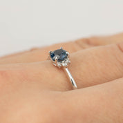 14k white gold ring with 0.65ct blue Montana sapphire and small brilliant cut diamonds on finger