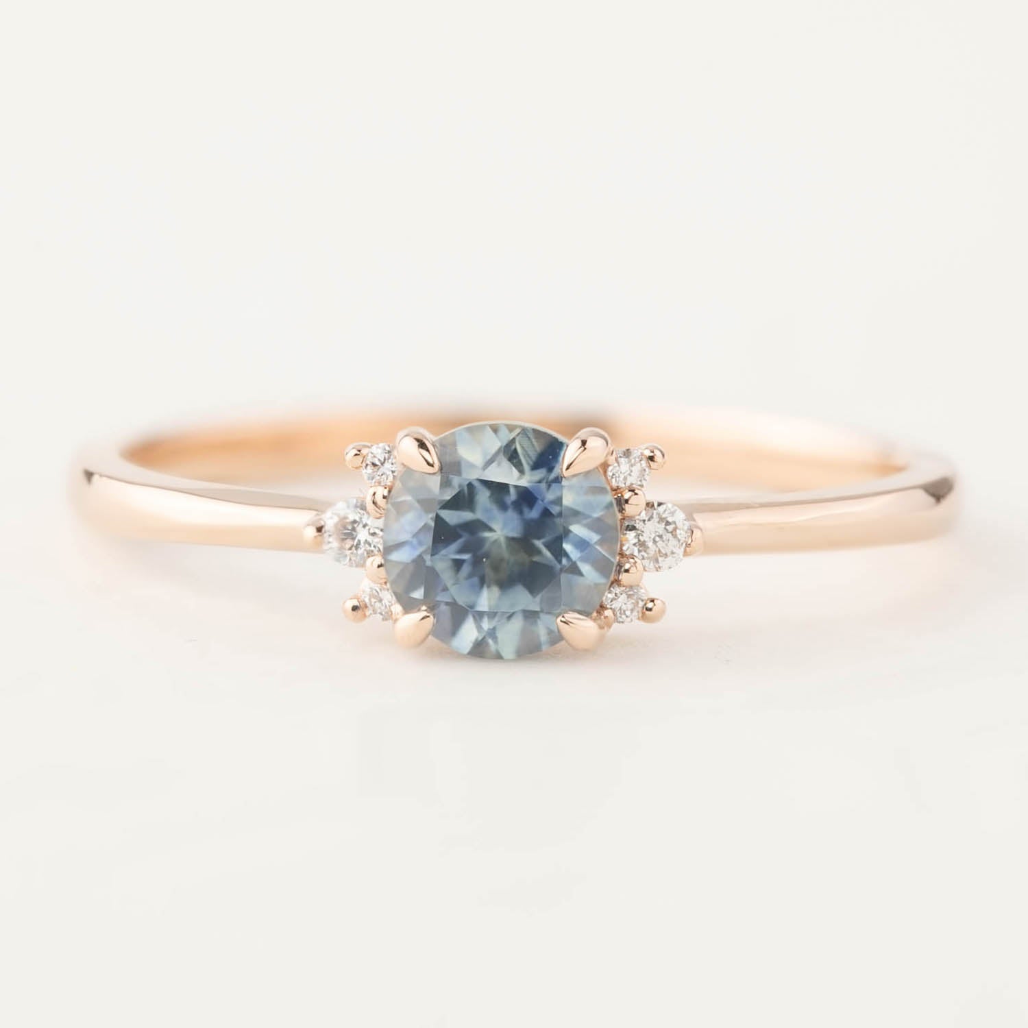 Rose gold ring with 0.72ct blue Montana sapphire center stone and small brilliant cut diamonds on either side