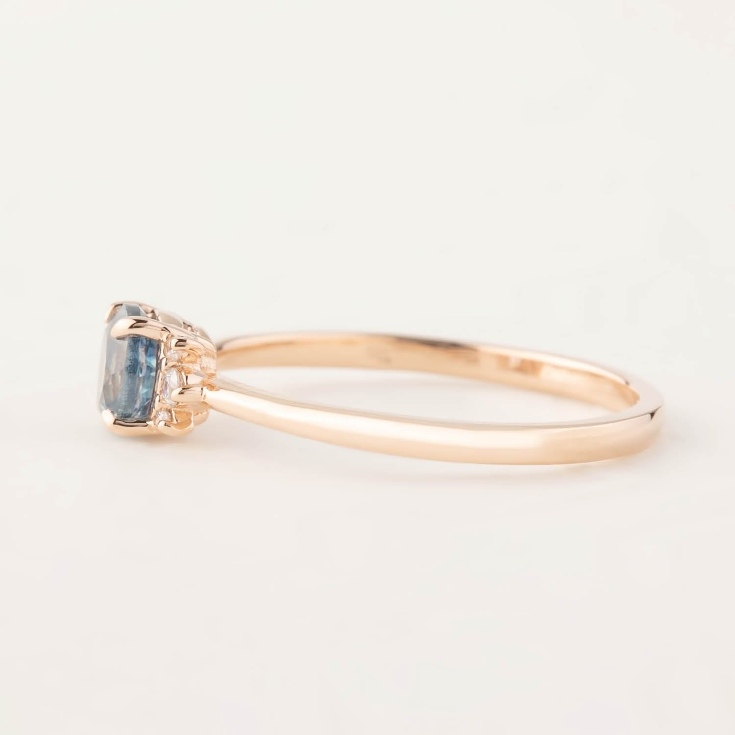 Side view of Lena Ring featuring 0.72ct blue Montana sapphire in 14k rose gold band with four-prong setting