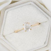 Gold ring with a heart-shaped gemstone on a soft white background