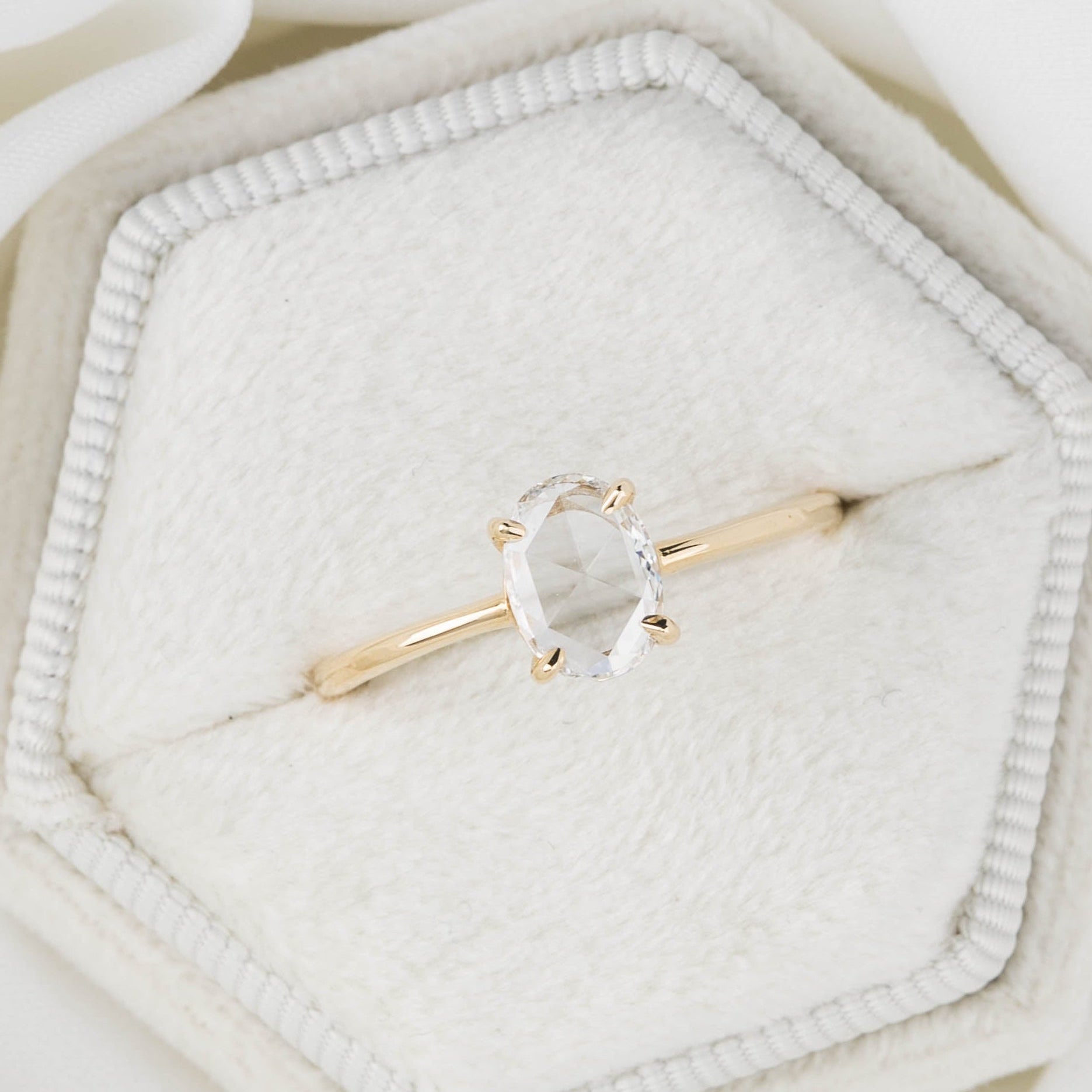 Gold ring with a heart-shaped gemstone on a soft white background