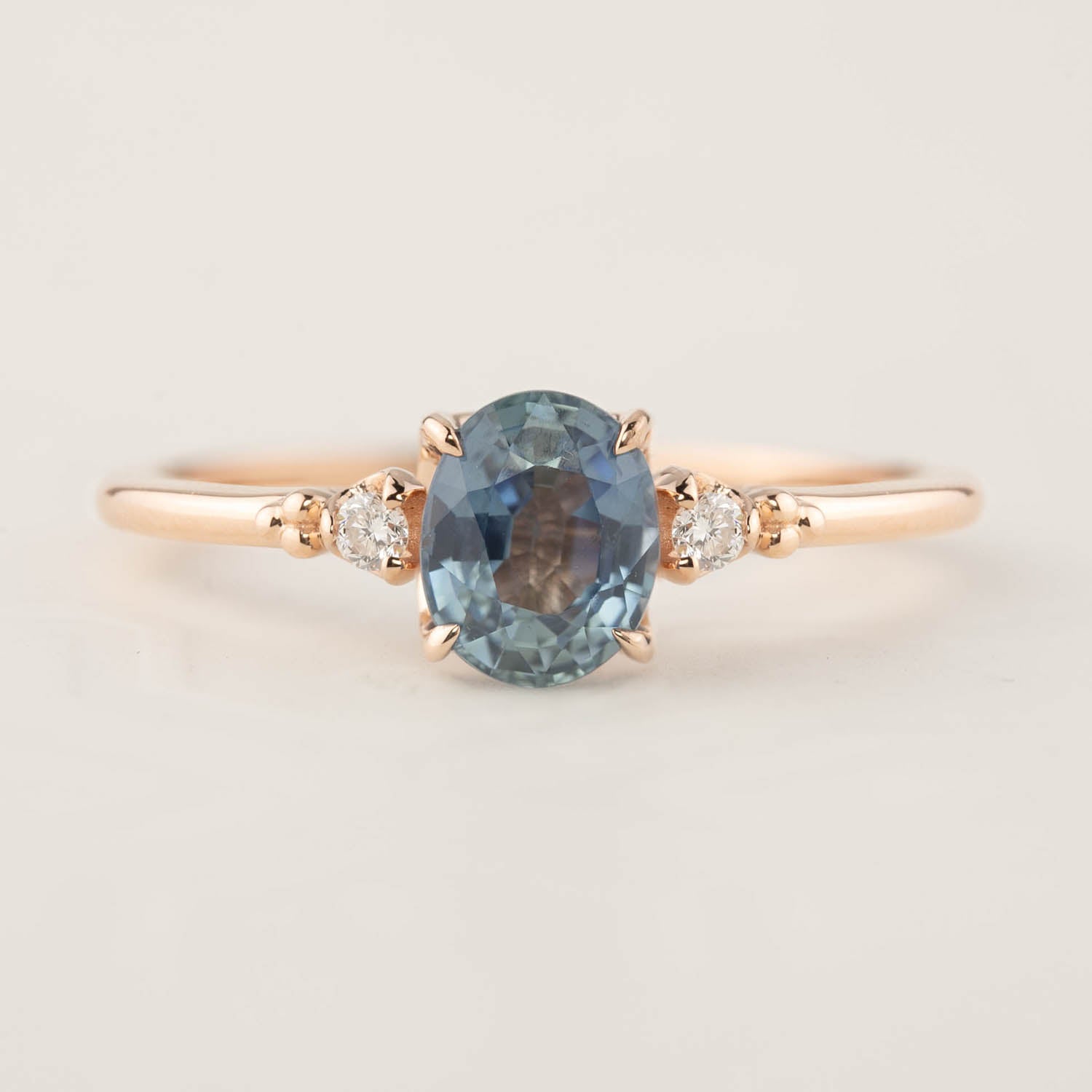 14k rose gold ring with 1.18ct blue sapphire center and two small accent diamonds, delicate band design