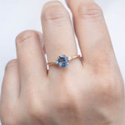 Estel Ring with 1.05ct blue sapphire and white accent diamonds in recycled 14k yellow gold, worn on hand