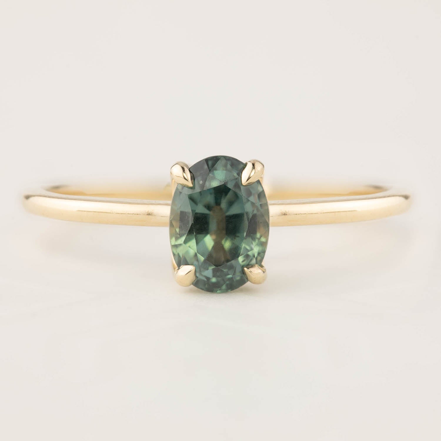 14k yellow gold ring with a 1.36ct oval green peacock sapphire in a high profile flower setting