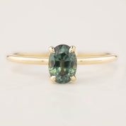 14k yellow gold ring with a 1.36ct oval green peacock sapphire in a high profile flower setting