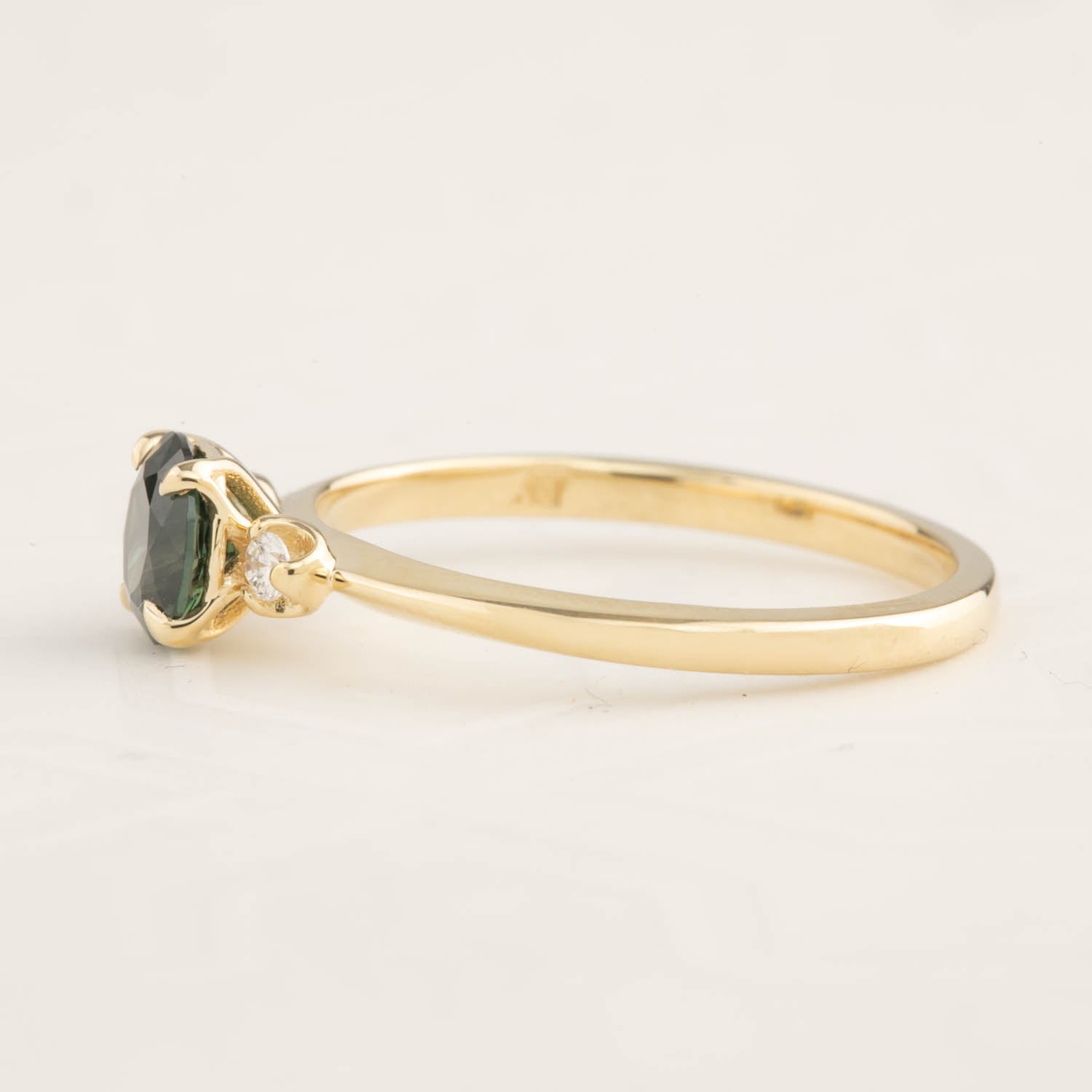 14k yellow gold ring with 0.85ct green Queensland peacock sapphire and small white accent diamonds side view